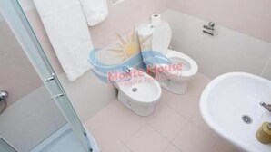 Une salle de bain comprenant des toilettes, un lavabo et une douche à parois en verre.