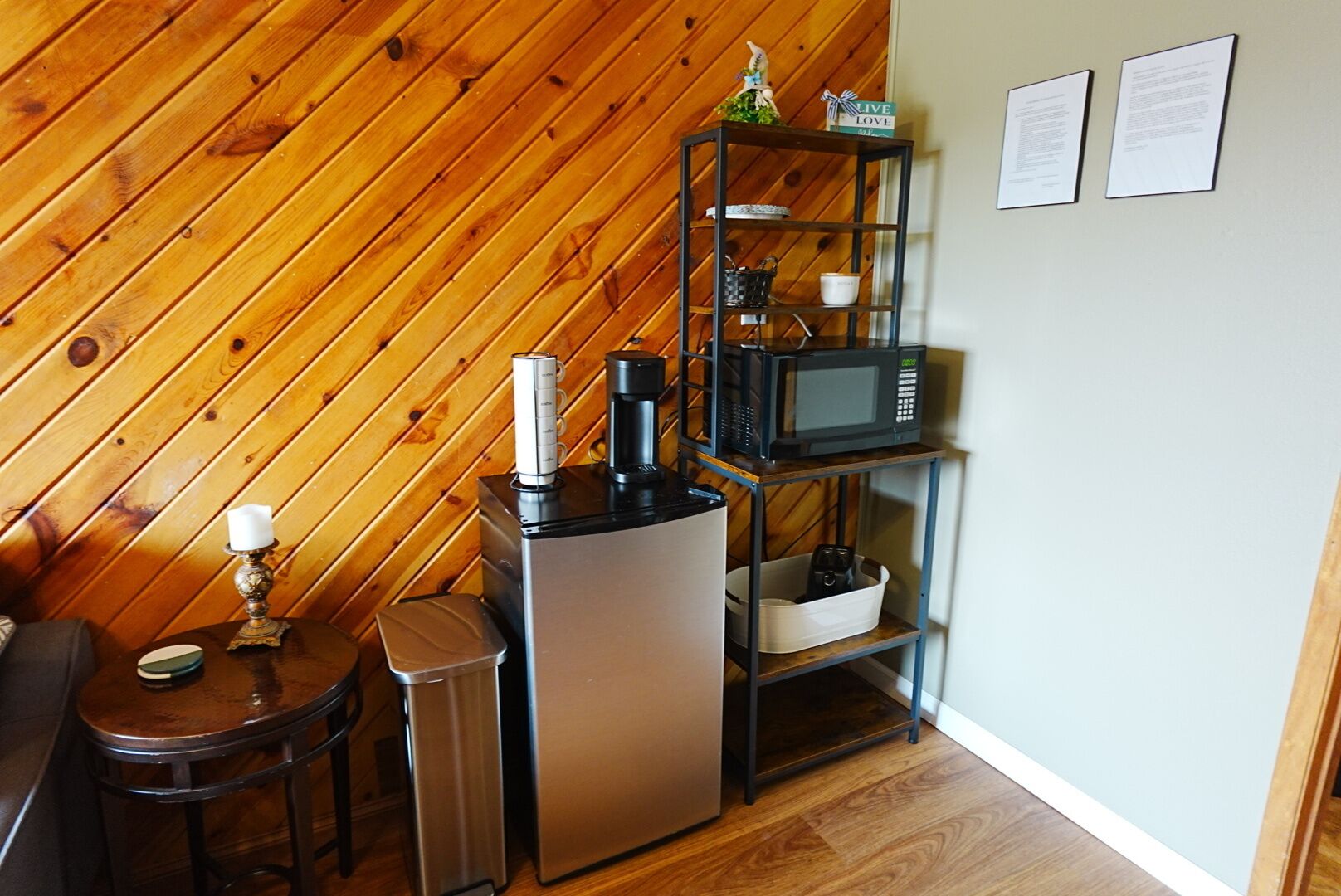 Una piccola cucina attrezzata con forno a microonde, macchina del caffè e frigorifero.