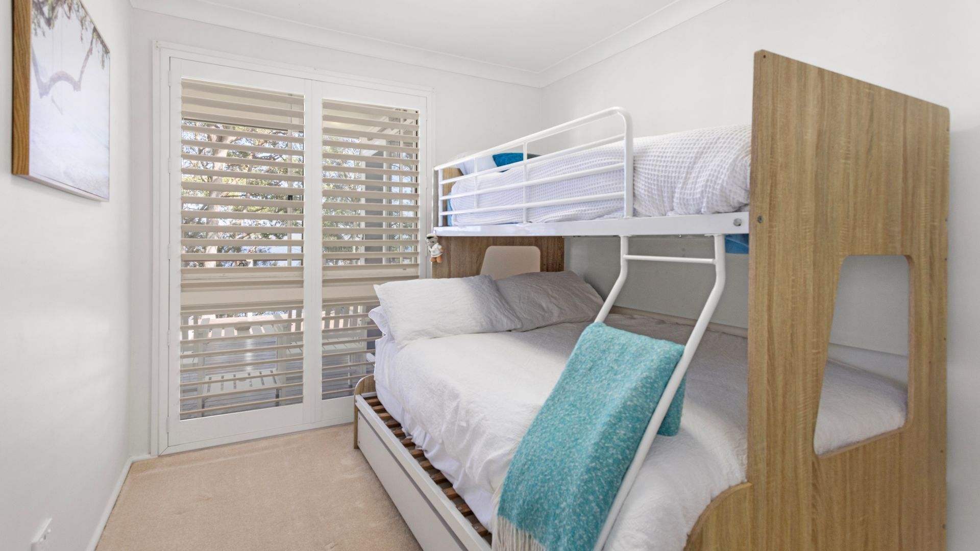 A bunk bed room with a window and a door.
