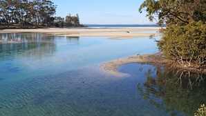 Un lac aux eaux limpides, bordé de plages de sable et entouré d’arbres.