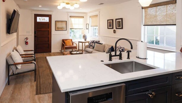 A modern kitchen with a large island, built-in appliances, and pendant lighting. - The Grand Helène - Newly Renovated 11BD, 12BA - 2 Blocks from King St! (Charleston)
