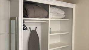 A white wardrobe with shelves, a hanging rack, and a mirror. - Near Rodney Bay! Breezy, Beachy and Spacious 1-Bedroom Unit. (Castries)