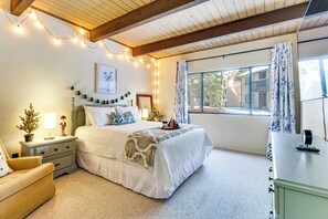 A cozy bedroom with a bed, bedside table, lamp, and a window with curtains. - Nat'l Forest Retreat at 'The Nest at Pinetop' (Pinetop)