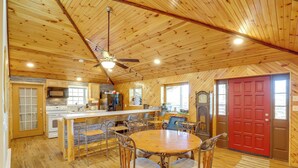 A spacious kitchen with wooden floors, a central island, and a red door. - 1 Mi to TIEC: Peaceful Mountain Cabin (Mill Spring)
