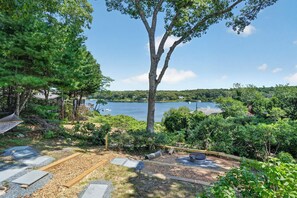 A lakeside property with a hammock, a fire pit, and a view of the lake. - Steps to Beach: Martha's Vineyard Private Retreat! (Vineyard Haven)