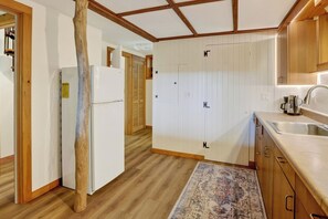 Eine Küche mit Holdekor, einem Kühlschrank und einer Spüle.