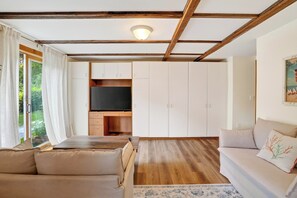 Ein Wohnzimmer mit einer Couch, einem Fernseher und einem Schrank.