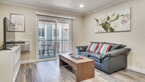 A living room with a sofa, a coffee table, and a sliding glass door leading to an outdoor area. - Shop, Hike & Sip Wine: Pleasanton Gem w/ Balcony! (Pleasanton)