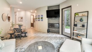 Ein modernes Wohnzimmer mit Essbereich, Kamin und Wandfernseher.