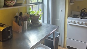 A kitchen with a stove, a sink, a window with blinds, and a potted plant on the counter. - Treelined street, hidden gem in a bamboo forest.  Walk to coffee shops/eateries! (San Marcos)