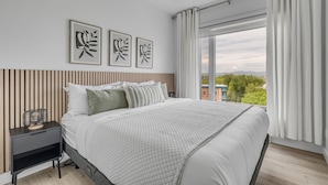 A modern bedroom with a large bed, a nightstand, and three wall-mounted artworks. - Magnificent downtown Penthouse with free underground parking (Québec)
