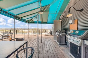 An outdoor patio with a covered seating area, a grill, and a view of the landscape. - Magnificent downtown Penthouse with free underground parking (Québec)