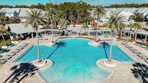 Ein großer, klarer Swimmingpool mit Liegestühlen und Palmen.