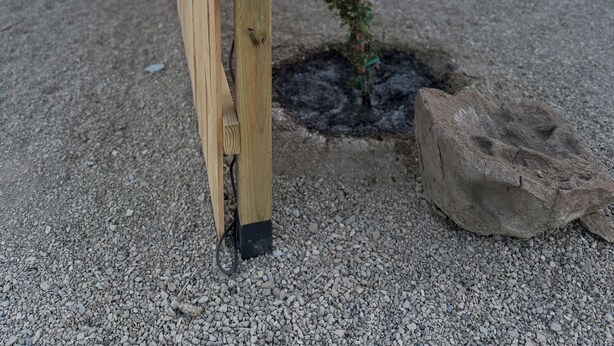Ein Schild mit der Aufschrift 'Ocotillo Vista', ein Holzpfosten, ein Felsen und eine Schotterfläche.