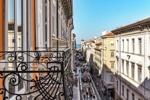 A narrow street with buildings on both sides, a clear sky, and a view of the sea in the distance. - Casa Saba Trieste Author's Terrace (Trieste)