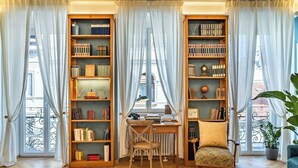 Eine gemütliche Leseecke mit einem Holztisch, einem Stuhl und Bücherregalen voller Bücher.