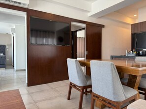 Un comedor moderno con una mesa de madera y dos sillas grises tapizadas.