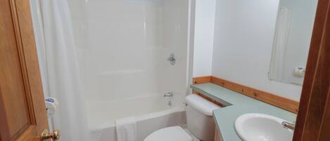 A bathroom with a bathtub, toilet, and sink.