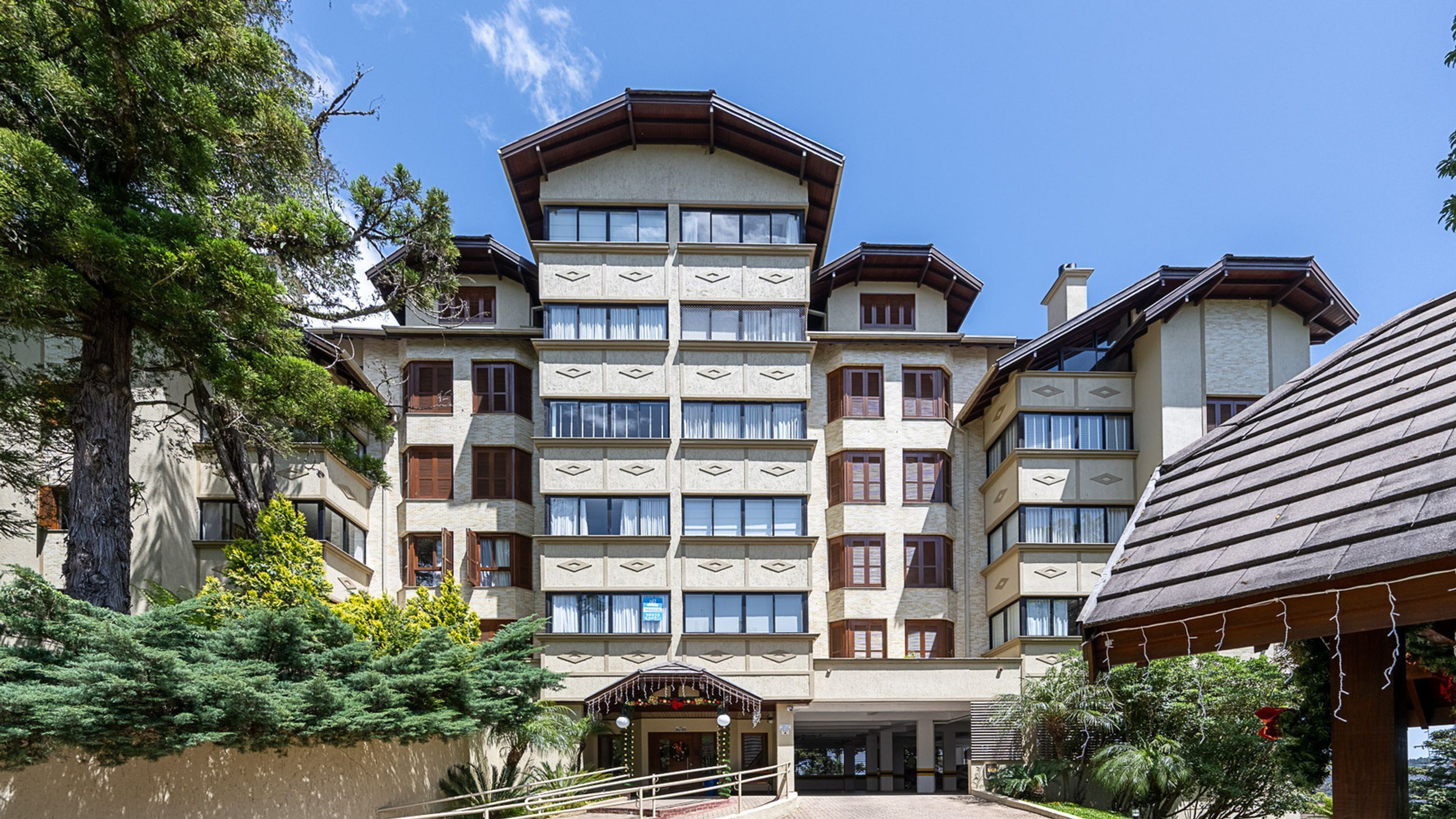 Un hotel de diverses plantes amb una façana simètrica, grans finestres i una entrada central.