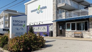 A hotel with a sign for 'Concord Suites' and a 'CORD CAFE' on the ground floor.