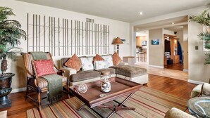 A living room with a sofa set, a coffee table, and a decorative wall piece.