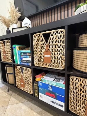 A bookshelf with woven baskets, books, and a 'HOME' sign. - Cozy 1-bedroom studio in marvelous Miami with AC (Miami)