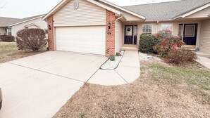 A single-story house with a garage, a front porch, and a small front yard. - Beautiful Historic Lebanon Illinois 2 Bedroom Villa (Lebanon)