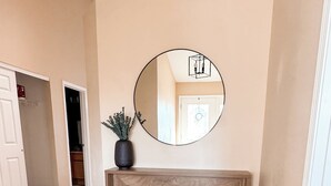 A spacious room with a wooden bench, a large mirror, and a potted plant. - Beautiful Historic Lebanon Illinois 2 Bedroom Villa (Lebanon)