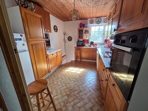 A kitchen with wooden cabinets, a refrigerator, a stove, and a sink. - Family house 6 pers, pets allowed, near beach (La Faute-sur-Mer)