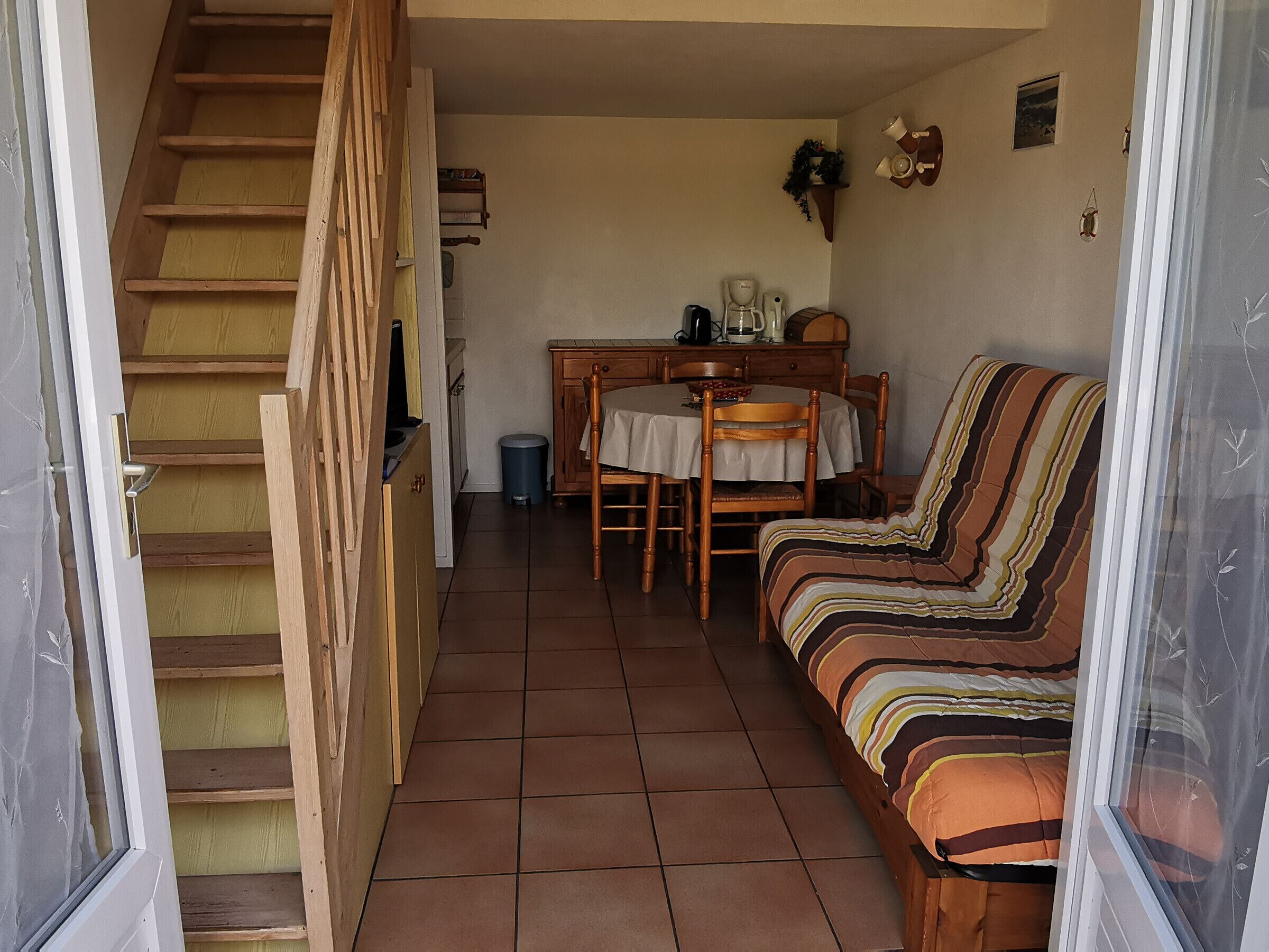 A compact living space with a staircase leading to a dining area.