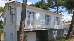 A two-story house with a balcony, stone foundation, and white exterior. - House for 8 near beach, pets allowed (La Tranche-sur-Mer)