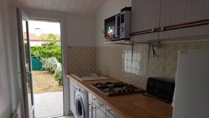 A compact kitchen with a washing machine, a microwave, and a refrigerator. - Quiet house near beach with parking and pets allowed (La Tranche-sur-Mer)