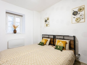 A bedroom with a bed, a window, and wall art. - Charming apartment, 4 people, medieval village Martel, Pets allowed, Free WiFi (Martel)