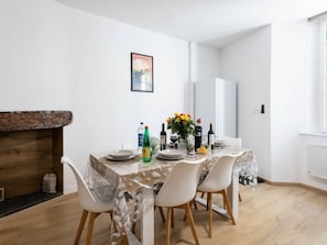 A dining area with a table set for four, a wooden bench, and a white wall with a framed picture. - Charming apartment, 4 people, medieval village Martel, Pets allowed, Free WiFi (Martel)
