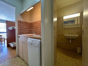 A compact kitchen with a dishwasher, a sink, and a tiled backsplash. - Studio for 4 near slopes with free wifi and parking (Le Dévoluy)