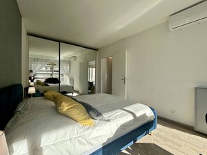 A modern bedroom with a large bed, a mirror, and a wardrobe. - 2-Room Apt in Villeneuve: AC, Sleeps 4 (Villeneuve-Loubet)