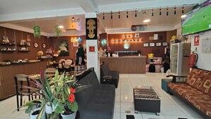 Un hall d’hôtel comprenant un comptoir d’accueil, un espace salon et un bar.