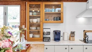 Eine Küche mit Holzausbau, einer Kaffeemaschine und einem Messerblock.