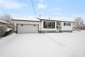 A single-story house with a garage and a front door, surrounded by snow. - Perfect Group Stay in Cornwall | 3BR +Theater Room (Cornwall)