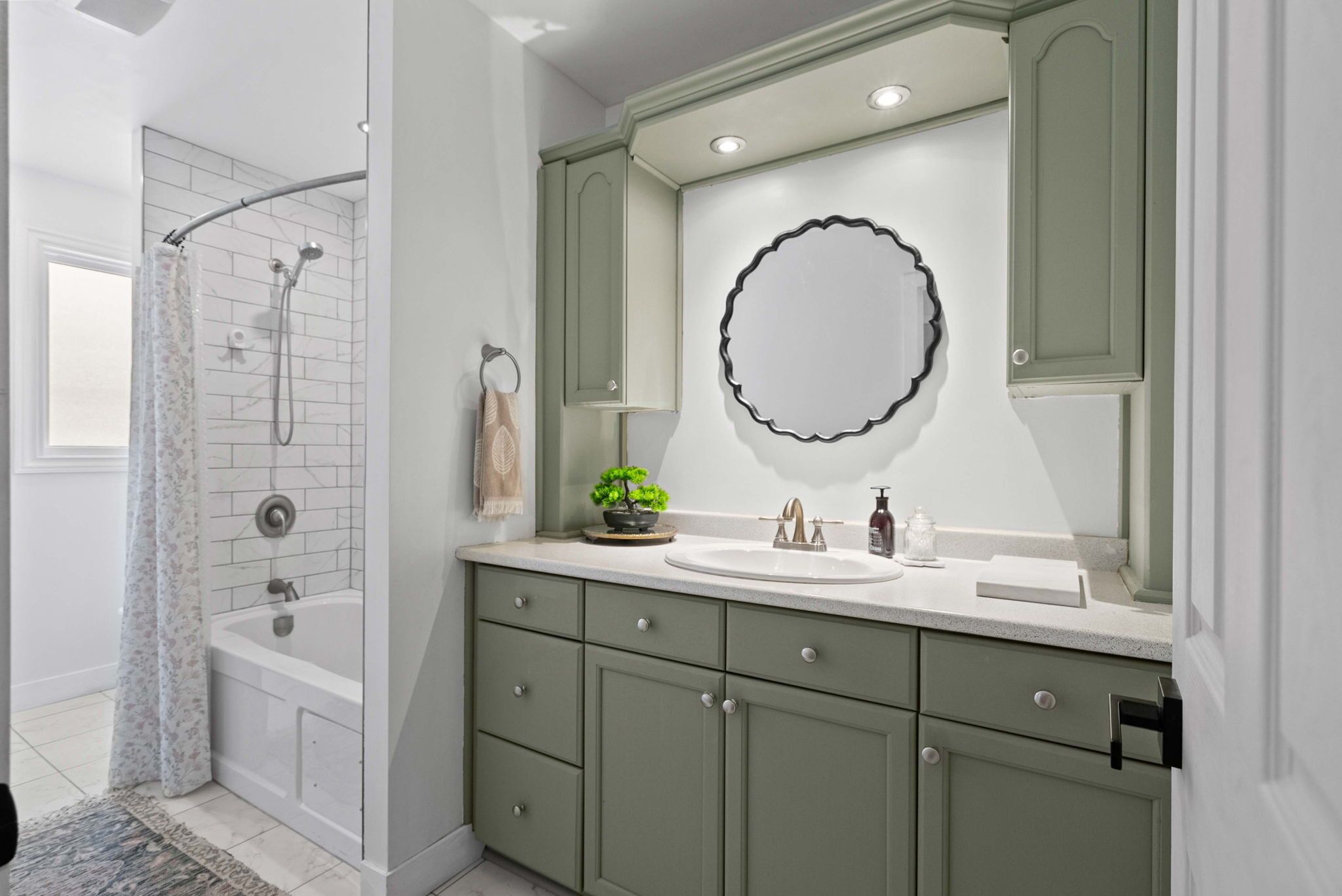 A bathroom with a bathtub, a shower, a sink, and a vanity with drawers.
