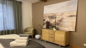 Ein modernes Schlafzimmer mit einem großen Bett, einem hölzernen Schminktisch und einem Bild an der Wand.