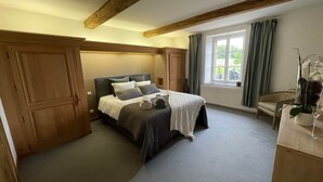 Ein Schlafzimmer mit einem großen Bett, einem Holzschrank und einem Fenster mit Vorhängen.