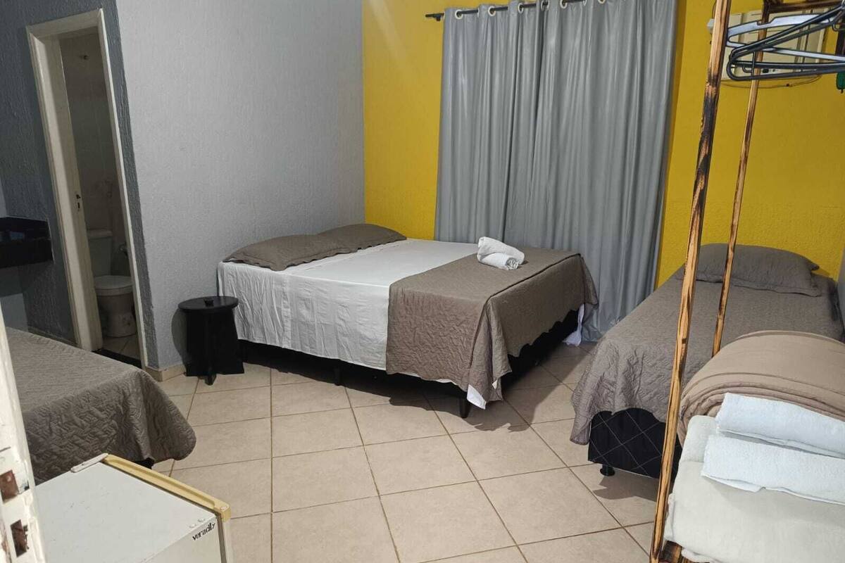 Ein kleines, gemütliches Hotelzimmer mit einem Einzelbett, einem Nachttisch und einem Stuhl.