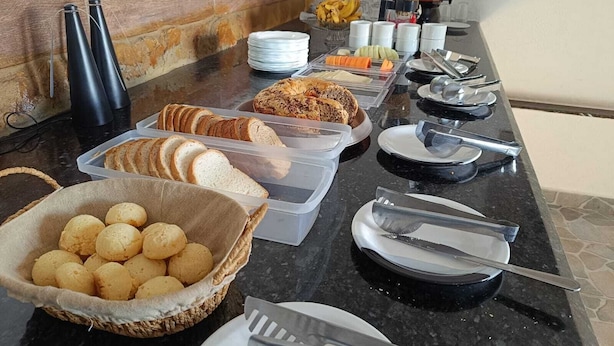 Un buffet proposant une variété de plats, notamment du pain, des pâtisseries et des fruits.