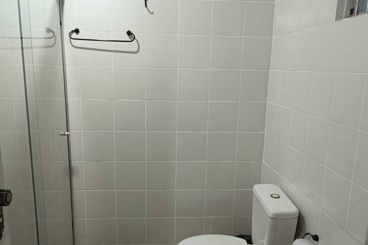 Ein kleines, sauberes Badezimmer mit Toilette, Waschbecken und Duschbereich.