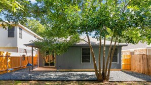 A backyard with a tree, a small shed, and a wooden fence. - Quiet Austin Stay Near Tech (Austin)