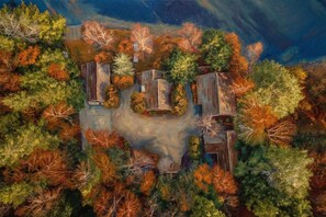 Vue aérienne d’une propriété dotée d’une cour centrale entourée d’arbres et de bâtiments.
