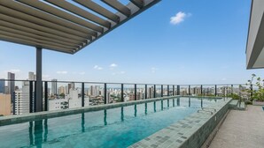 A rooftop infinity pool with a cityscape view, a pergola, and a safety railing. - Studio With Balcony in Building With Pool Urb1406 (Salvador)