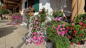 A traditional building with a welcoming sign, surrounded by vibrant flower arrangements. - in ruhiger Lage nahe am See by Interhome (Thiersee)
