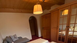 A bedroom with a large bed, a sofa, and a wardrobe. - in ruhiger Lage nahe am See by Interhome (Thiersee)